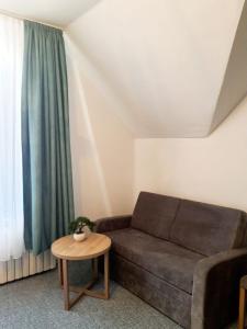 a living room with a couch and a table at Hotel Knöpel in Wismar