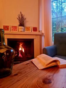 un libro abierto sobre una mesa con chimenea en La Casa Junto al Sendero del Río & Chimenea y leña incluida, en Los Romeros
