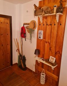Habitación con pared de madera, estante y puerta. en La Casa Junto al Sendero del Río & Chimenea y leña incluida, en Los Romeros