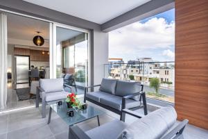 a living room with a couch and chairs on a balcony at Sunflower 1-Bedroom Apartment in Larnaca in Larnaka