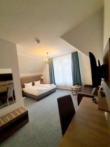 Hotel Knöpel في فيسمار: غرفة معيشة كبيرة مع سرير وأريكة