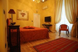 1 dormitorio con 1 cama, 1 silla y TV en Residenza d'Epoca Palazzo Galletti en Florencia