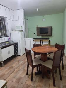 a kitchen with a table and chairs and a microwave at Chalé Terê na Serra da Canastra in São Roque de Minas