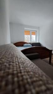 1 dormitorio con 2 camas y ventana en Kr.Valdemara en Daugavpils