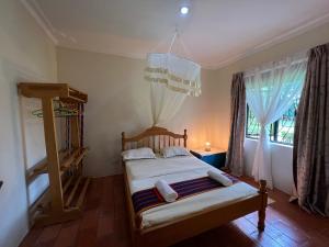 a bedroom with a bed and a window at Farm Cottage in Mukono