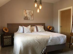 a bedroom with a bed with white sheets and pillows at Chestnut House, Ashlin Farm Barns in Lincoln