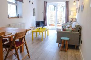 a living room with a table and a couch at Spacious two bedroom, two bathroom Beach Nest with garden in St. Leonards