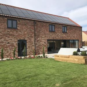 una casa in mattoni con pannelli solari di Chestnut House, Ashlin Farm Barns a Lincoln