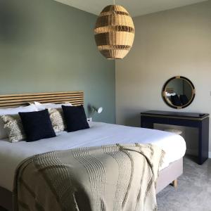 a bedroom with a large bed and a mirror at White Swan Cottage, Ashlin Farm Barns in Lincoln
