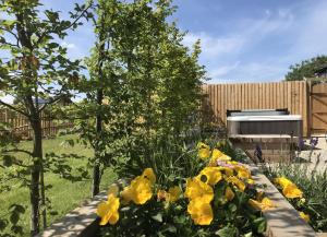 un giardino con fiori gialli e una recinzione di White Swan Cottage, Ashlin Farm Barns a Lincoln