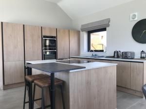 a kitchen with wooden cabinets and a black counter top at White Swan Cottage, Ashlin Farm Barns in Lincoln