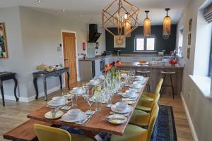 uma sala de jantar com uma mesa longa e cadeiras em Field Maple Barn, Ashlin Farm Barns em Lincoln