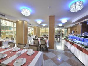 a dining room with tables and chairs and chandeliers at Rhiss Hotel Bostanci in Istanbul