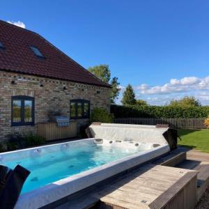 a large swimming pool in the backyard of a house at Field Maple Barn, Ashlin Farm Barns in Lincoln