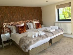 um quarto com uma cama grande e toalhas em Meadowsweet Barn, Ashlin Farm Barns em Lincoln