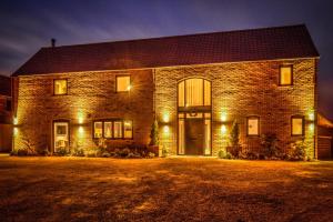 a brick house with lights on the front of it at The Elms, Ashlin Farm Barns in Lincoln