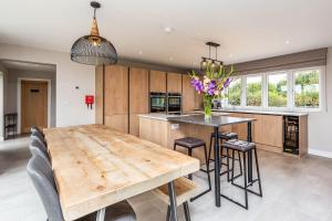 a kitchen with a wooden table and some chairs at The Elms, Ashlin Farm Barns in Lincoln