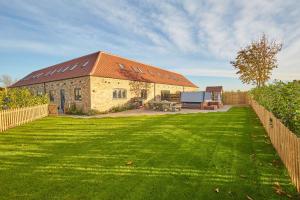 un edificio in mattoni con un tetto sopra un cortile di Holly Tree Barn, Ashlin Farm Barns a Lincoln