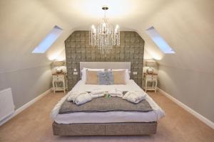 una camera da letto con un letto grande e un lampadario di Holly Tree Barn, Ashlin Farm Barns a Lincoln Altre 10 foto