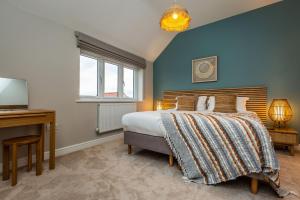 a bedroom with a bed and a desk and window at The Sycamores, Ashlin Farm Barns in Lincoln