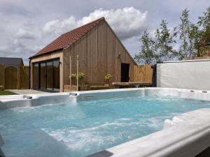 a large swimming pool in front of a building at The Pines, Ashlin Farm Barns in Lincoln