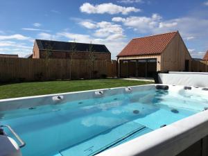 una vasca idromassaggio in un cortile con recinzione di The Willows, Ashlin Farm Barns a Lincoln