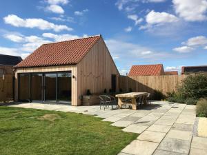 einem Holzschuppen mit einem Tisch und einer Bank in der Unterkunft The Willows, Ashlin Farm Barns in Lincoln