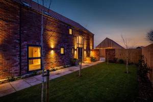 a brick house with a lawn in front of it at The Birches, Ashlin Farm Barns in Lincoln