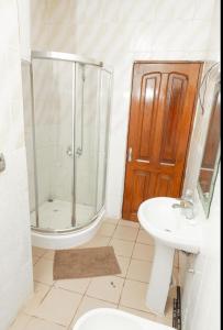 La salle de bains est pourvue d'une douche, de toilettes et d'un lavabo. dans l'établissement DUPLEXE HAUT STANDING centre ville Quartier Fouda, à Yaoundé