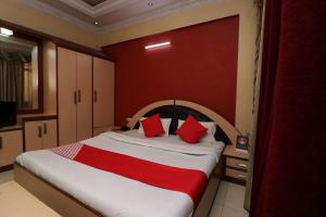 a bedroom with a large bed with red walls at Akash Regency in Dhanbād