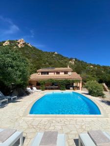 a large swimming pool in front of a house at Villa Bellavista con piscina privata, vista mare vicino a Villasimius in Villasimius