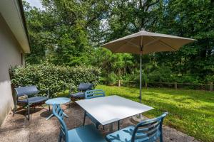 un tavolo e sedie con ombrellone in un cortile di Terres de France - Le Domaine Du Golf a Saumur