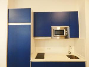 una cucina con armadi blu e forno a microonde di Echegaray Premium cathedral 1 a Málaga Altre 16 foto