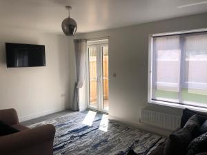 a living room with a couch and a window at Barber House, Hoyland in Hoyland Nether