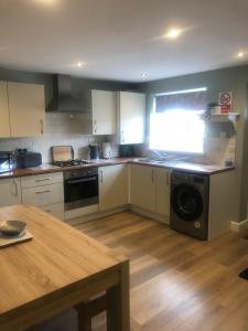 a kitchen with a stove and a dishwasher at Barber House, Hoyland in Hoyland Nether