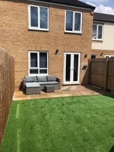 a garden with a couch in the backyard of a house at Barber House, Hoyland in Hoyland Nether