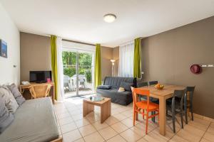 uma sala de estar com um sofá e uma mesa em Terres de France - Le Domaine Du Golf em Saumur