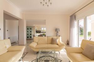 Sala de estar con 2 sofás y mesa en Villa Kamos, en Archangelos