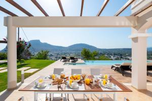 a dining table on a patio with a view at Villa Kamos in Archangelos