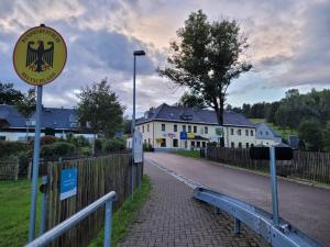 una señal en el costado de una carretera junto a una valla en Pension Grenzhof, en Neuhausen