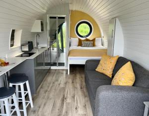 a living room with a couch and a bed in a room at Yr Onnen in Oswestry