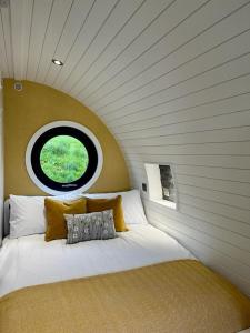 a bedroom with a large bed with a round window at Yr Onnen in Oswestry
