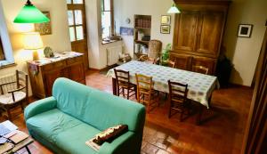 a living room with a green couch and a table at Ferme des Trois Poiriers, Teloché in Teloché