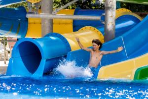 a man sliding down a water slide in the water at Prestige Hotel and Aquapark - All inclusive in Golden Sands