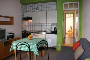 a small kitchen with a table with a green wall at Hospedaria Verdemar in Horta