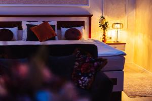 sypialnia z łóżkiem z poduszkami i lampą w obiekcie Hotel Baltaci Atrium w Zlinie