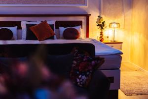 a bedroom with a bed with pillows and a lamp at Hotel Baltaci Atrium in Zlín