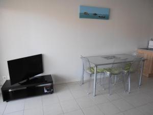 a kitchen with a table and a tv and chairs at Appartement Hendaye, 2 pièces, 4 personnes - FR-1-2-291 in Hendaye