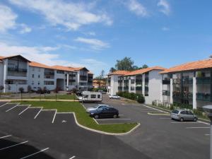 a parking lot at a apartment complex with cars parked at Appartement Hendaye, 2 pièces, 4 personnes - FR-1-2-291 in Hendaye