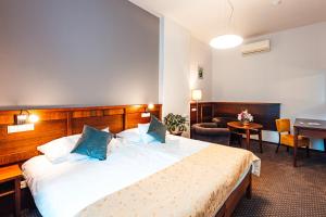 a hotel room with a large bed with blue pillows at Hotel Baltaci Atrium in Zlín